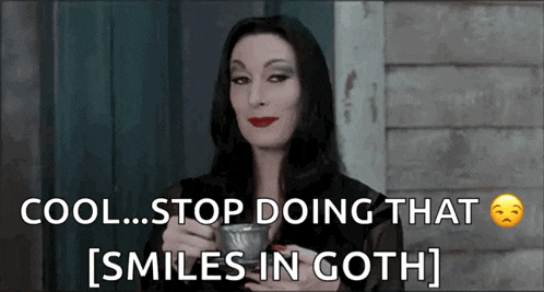a woman in a black dress is holding a cup and says cool stop doing that [ smiles in goth ] .