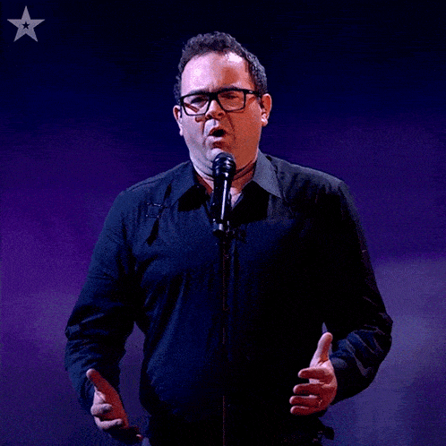 a man singing into a microphone with a star on the bottom right