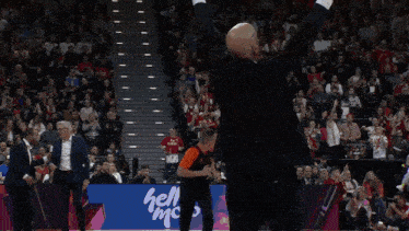 a man in a black suit stands in front of a basketball player wearing a green jersey with the number 1 on it