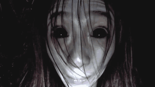 a woman with long hair and black eyes looks scary