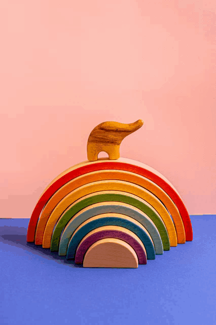 a wooden rainbow with an elephant on top