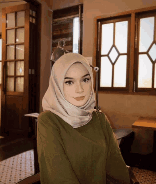 a woman wearing a white hijab looks at the camera