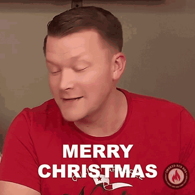 a man wearing a red shirt with the words merry christmas on it