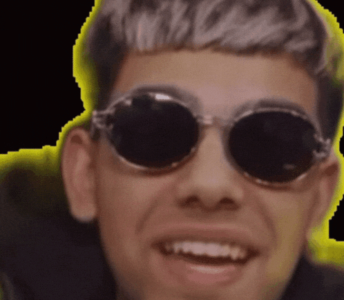 a close up of a man wearing round sunglasses smiling