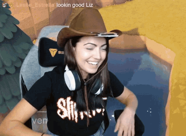 a woman wearing a cowboy hat and headphones is smiling with the words lookin good liz above her