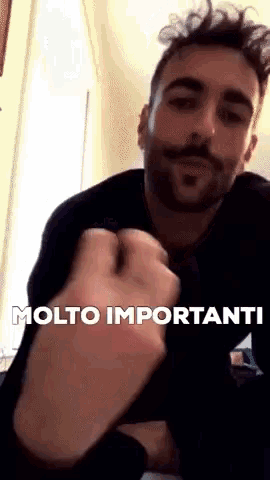 a man with a beard and mustache is making a fist with the words molto importanti above him