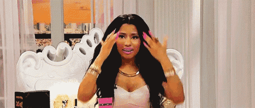 a woman with long black hair and pink nails is sitting in a chair