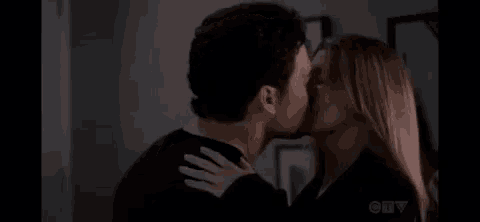 a man and a woman are kissing each other in a dark room .