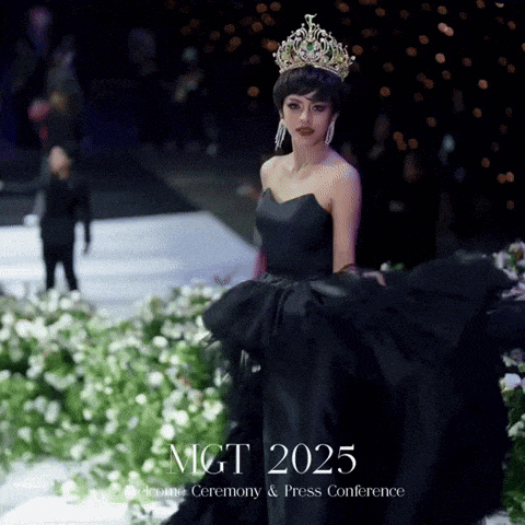 a woman wearing a black dress and a crown stands on a stage with mgt 2025 written on the bottom