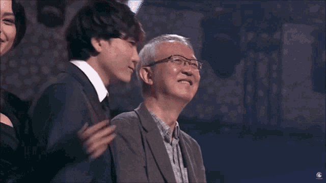 a man wearing glasses stands next to another man