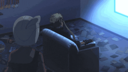 a man and a cat are sitting in a dark room looking at a tv screen