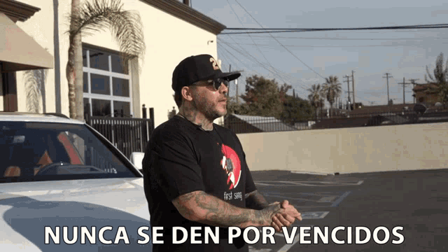 a man standing in front of a car with the words " nunca se den por vencidos " written below him