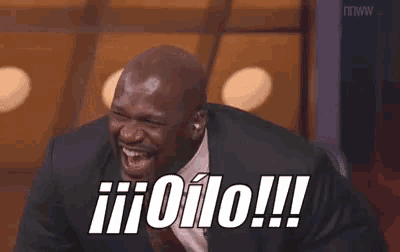 a man in a suit and tie is laughing with the words ii olo !! written on his face .