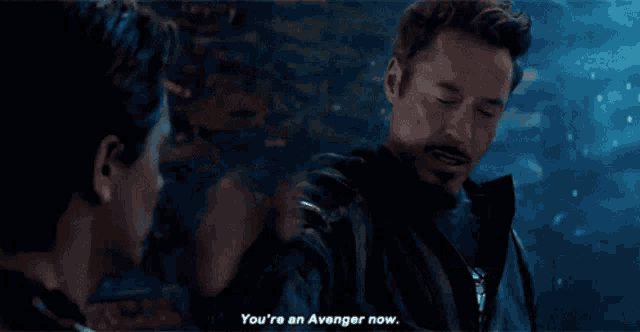 a man in a black jacket is talking to another man and says you 're an avenger now .