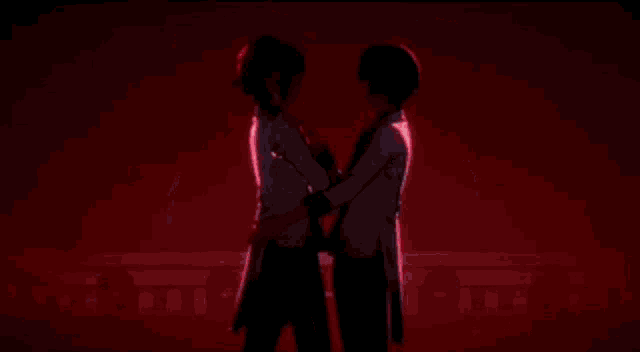 a couple of anime characters are hugging each other in front of a red heart .