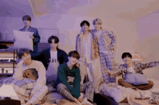a group of young men are sitting on a bed in a room .