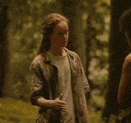 a woman in a camouflage shirt is talking to another woman