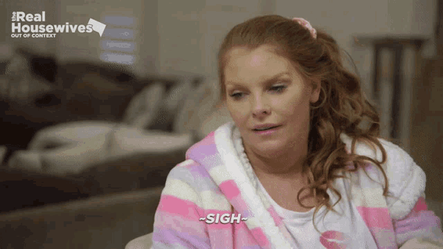 a woman is wearing a pink and white striped robe and says sigh