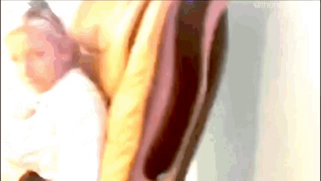 a blurry picture of a person holding a baby in a crib .