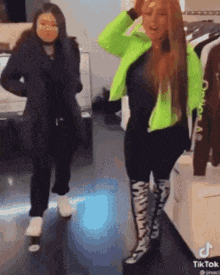 two women are standing next to each other in a clothing store .