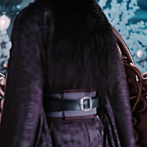 a person wearing a purple coat with a belt that has a silver buckle