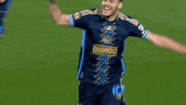 a soccer player in a blue adidas jersey is screaming