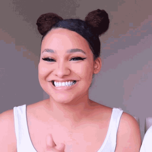 a woman with two buns on her hair is smiling
