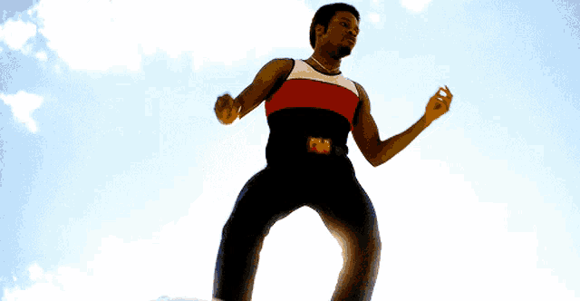 a man in a red white and black tank top with the letter f on the belt