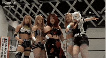 a group of female wrestlers are posing for a picture in front of a stardom logo