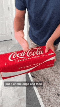 a man is holding a box of coca cola