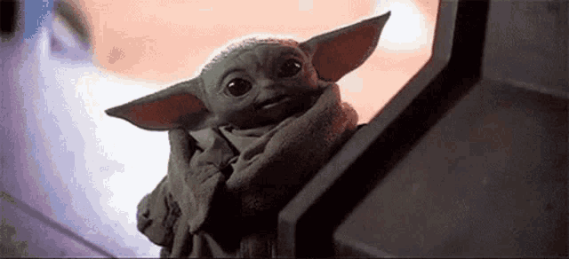 a baby yoda from star wars is sitting on a staircase .