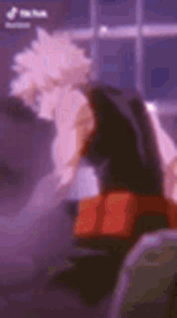 a blurred image of a person sitting on a chair in front of a window .