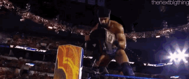 a wrestler is holding a world heavyweight championship belt while standing in front of a crowd .