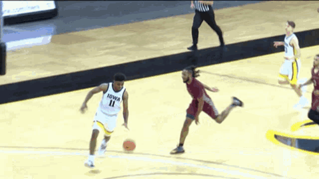 a basketball player with iowa 11 on his jersey dribbles the ball