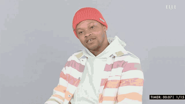 a man wearing a striped shirt and a red beanie has a timer of 0:07 and 1:15