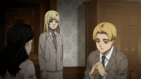 a man in a suit and tie sits in a room with two women