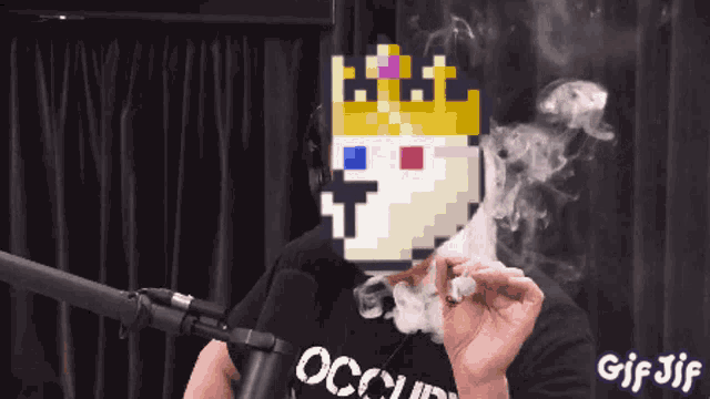 a man wearing an occupy shirt is smoking a cigarette in front of a microphone