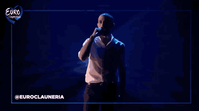 a man singing into a microphone in front of a euro cleaners sign