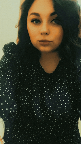 a woman in a black dress with white polka dots