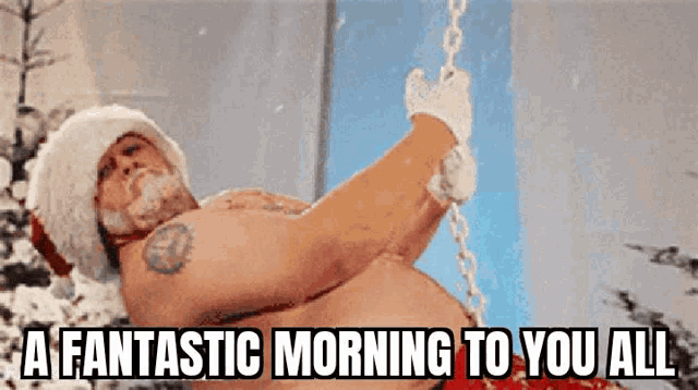 a shirtless man in a santa hat is hanging from a chain with the words " a fantastic morning to you all " below him