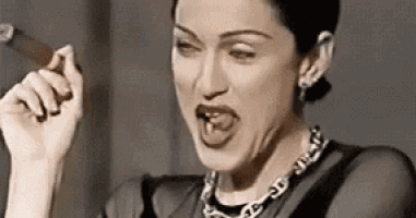 a woman is smoking a cigar and making a face .