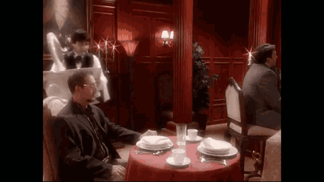 a priest is sitting at a table in a dining room with other people