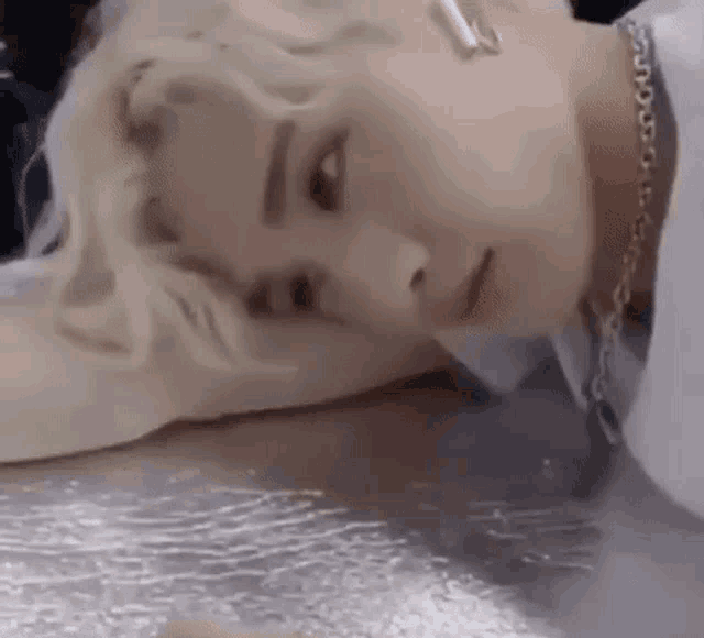 a close up of a person laying on a table with a necklace .