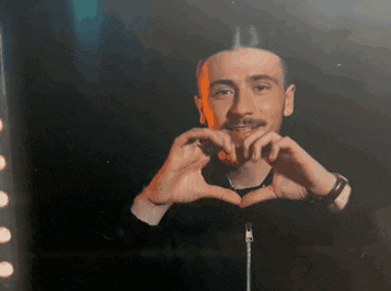 a man makes a heart shape with his hands