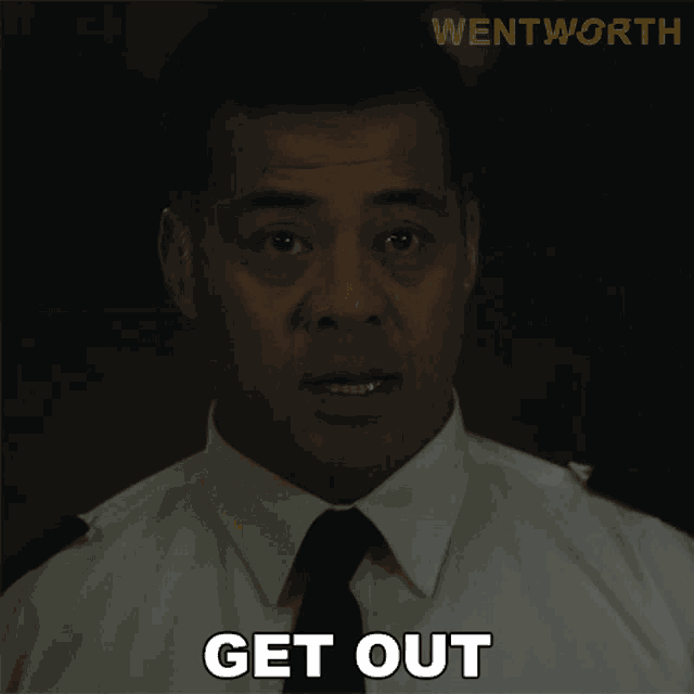 a man in a white shirt and black tie says " get out "