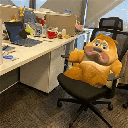 a teddy bear is sitting in an office chair next to a desk .