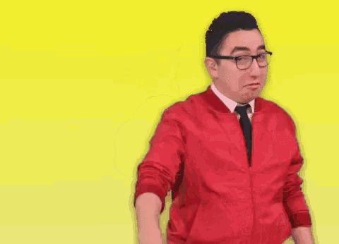 a man wearing glasses and a red jacket giving two thumbs up
