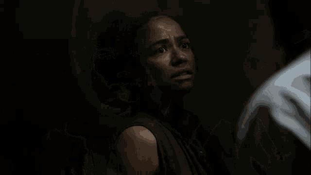 a woman with her hands on her head is looking at a man