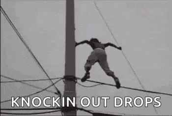 a man is standing on a telephone pole .