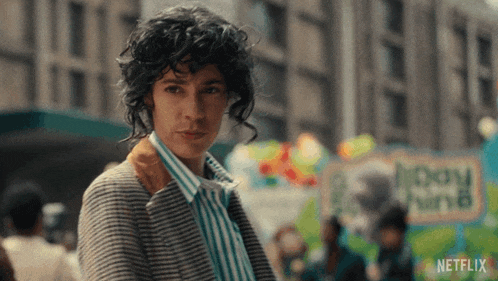 a woman with curly hair is standing in front of a sign that says netflix on it